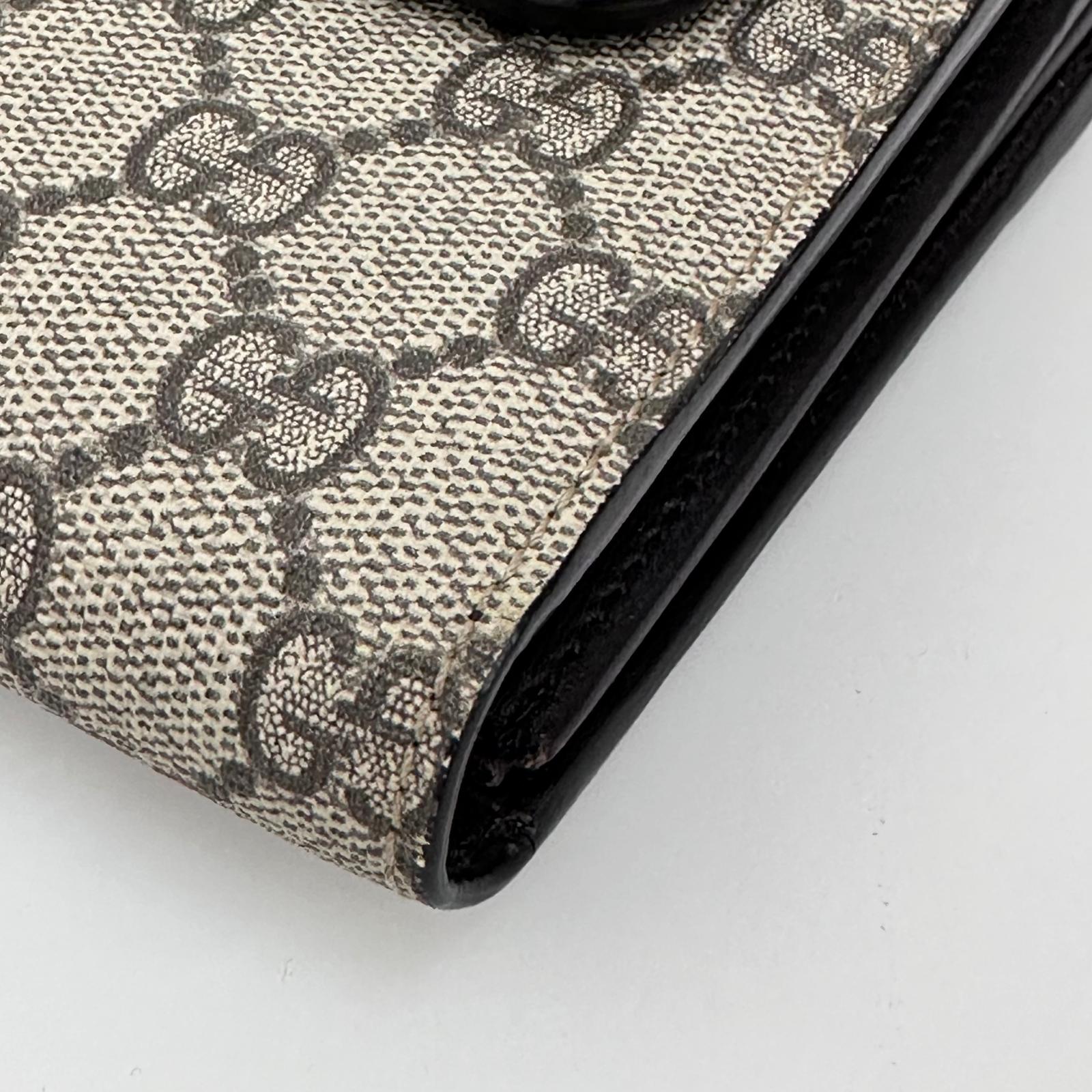 Gucci Clutch a mano GG Supreme con laccetto in pelle testa di moro